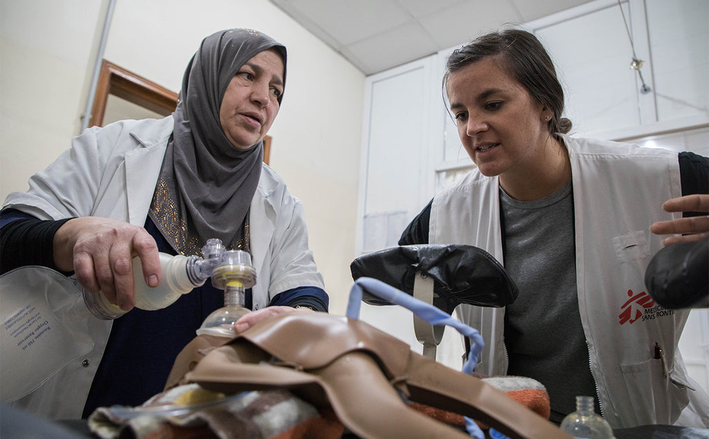 Une employée de MSF aidée par une collègue utilise un insufflateur manuel sur un mannequin de formation.